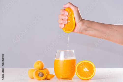 Fotografi woman's hand squeezing and squeezing half orange