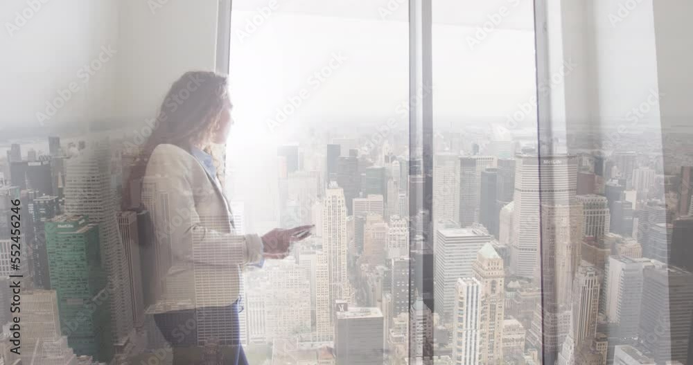 Animation of cityscape over biracial businesswoman in office Animation of cityscape over biracial businesswoman in office