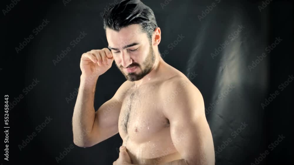 Young Bare Muscular Young Man Receiving Water Splashes in Studio Young Bare Muscular Young Man Receiving Water Splashes in Studio