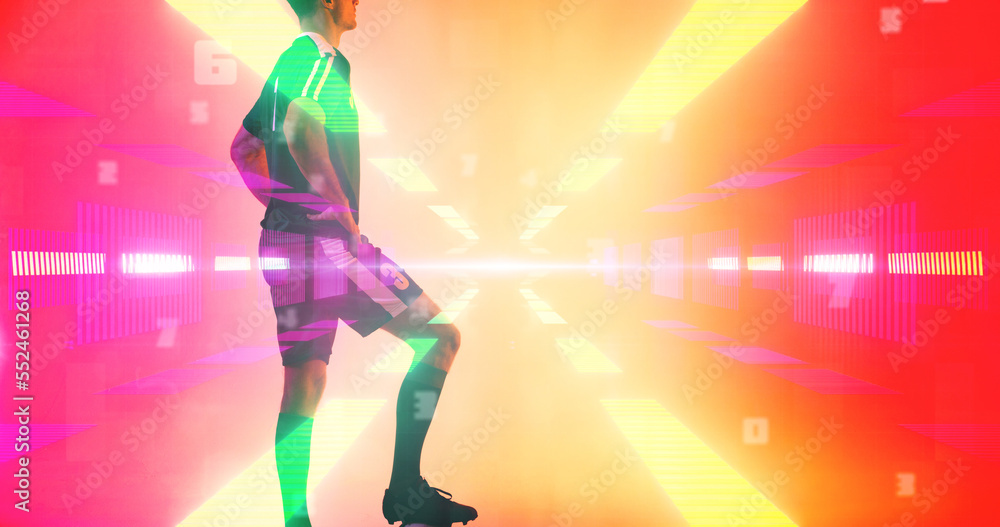 Young player with arms akimbo over bright neon soccer field over yellow and red background