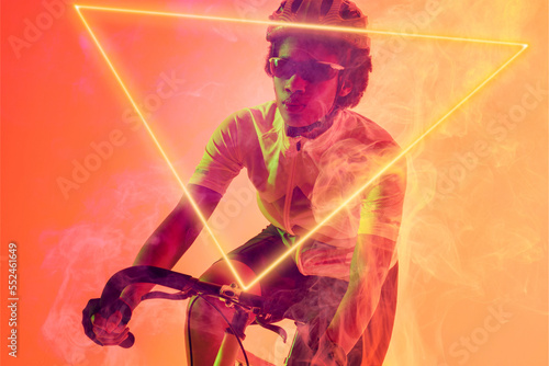 Triangle neon over confident african american cyclist riding bicycle against orange background
