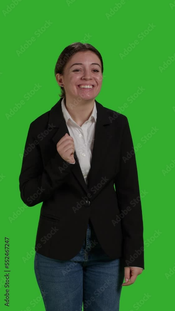 Vertical video: Front view close up of smiling businesswoman waving hello or goodbye in studio, doing greeting gesture over greenscreen backdrop. Cheerful manager saying hi, wearing suit on full body Vertical video: Front view close up of smiling businesswoman waving hello or goodbye in studio, doing greeting gesture over greenscreen backdrop. Cheerful manager saying hi, wearing suit on full body