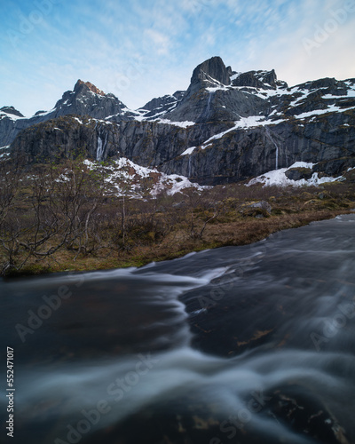 Mountain peaks rise above flowing stream, Lofoten Islands, Norway