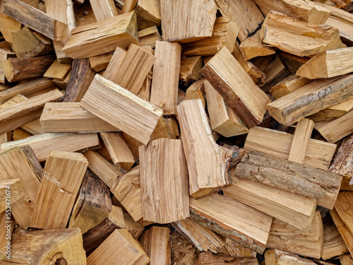 Chopped down tree trunks, firewood stacked in a storage yard, for heating in winter. Selective focus