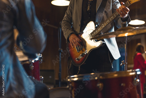Unrecognizable man playing electric guitar inside a music band. High quality photo