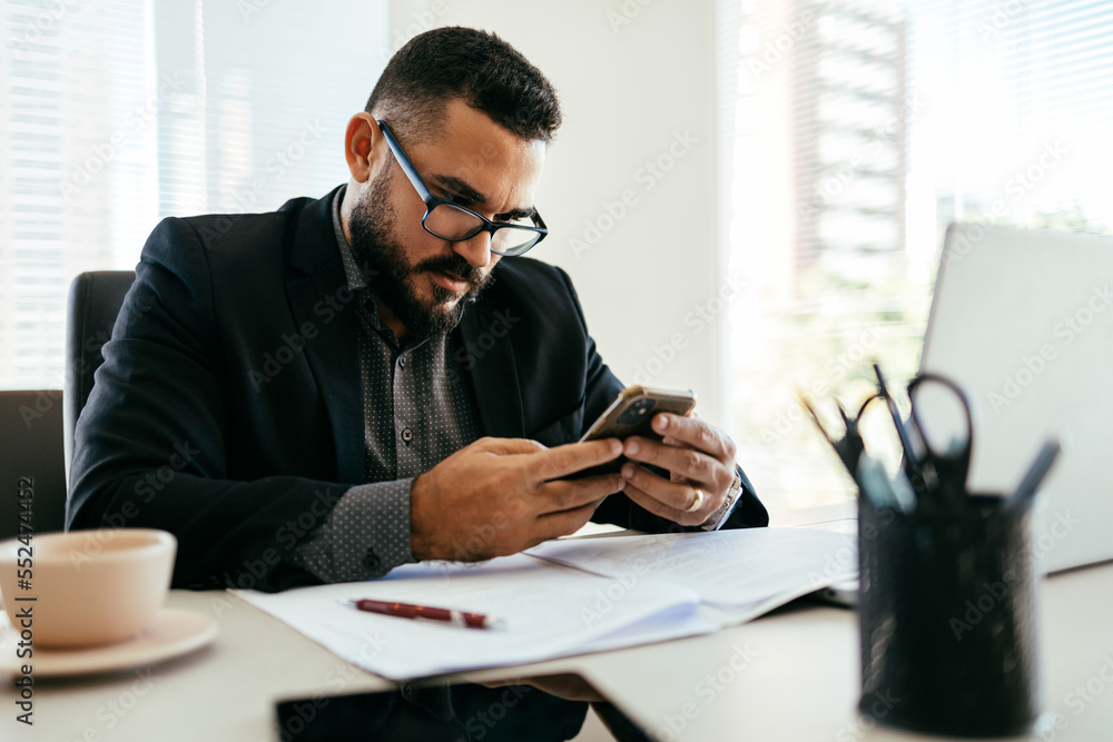 Young Brazilian businessman working on laptop in modern office Young Brazilian businessman working on laptop in modern office
