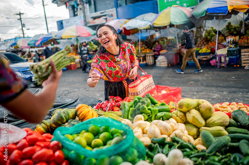 Retrato de Una Mujer feliz comprando espárragos frescos en un mercado local. 
