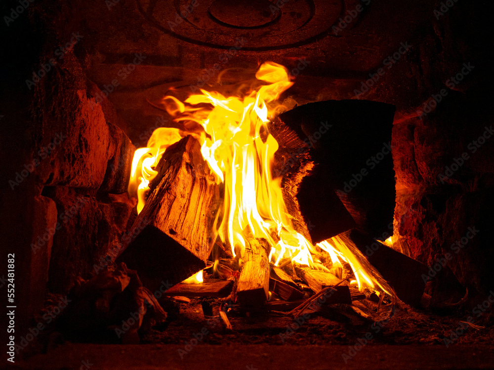 orange burning wood in a stone oven inside, fire in the fireplace