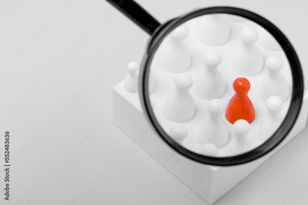 Magnifying glass over pawns on white background, space for text. Recruiter searching employee Magnifying glass over pawns on white background, space for text. Recruiter searching employee