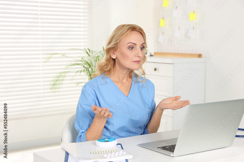 Doctor with laptop consulting patient in clinic. Online medicine concept Doctor with laptop consulting patient in clinic. Online medicine concept