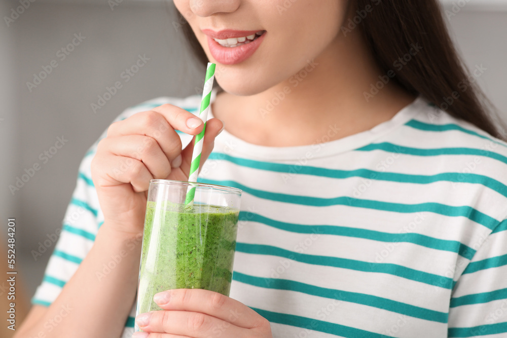 Young woman drinking tasty smoothie on grey background, closeup view Young woman drinking tasty smoothie on grey background, closeup view