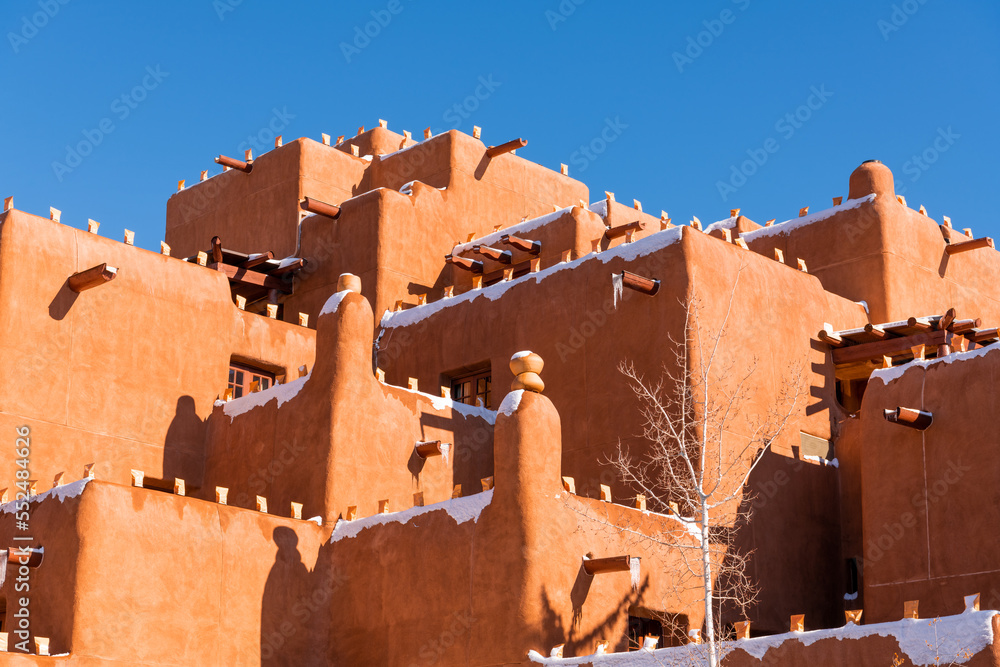 Naklejka premium Winter scene of snow-covered adobe pueblo style building in Santa Fe, New Mexico