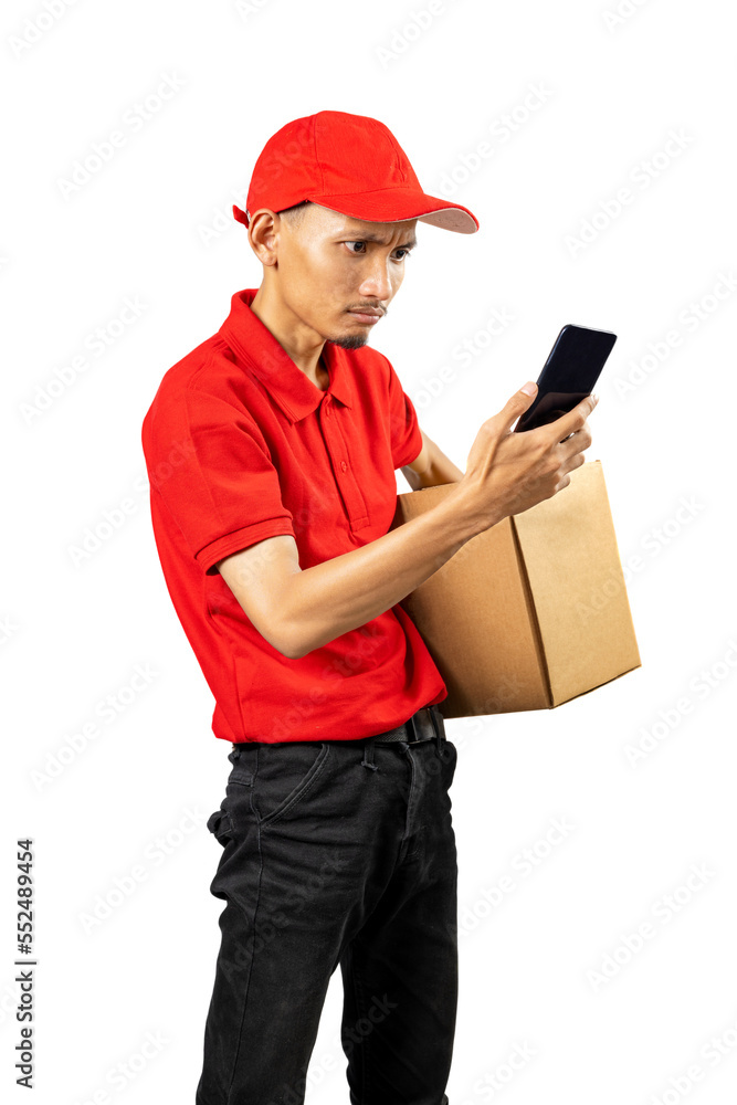 Parcel delivery man with a hat holding a mobile phone while carrying a package Parcel delivery man with a hat holding a mobile phone while carrying a package