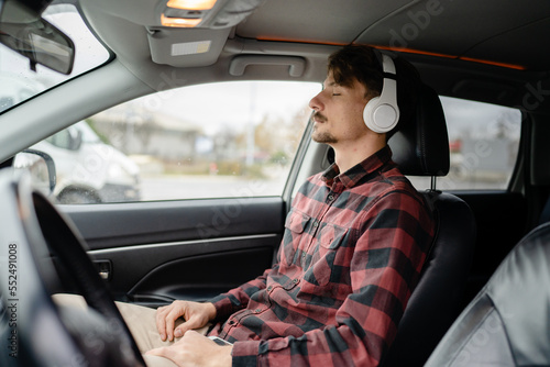 one man with headphones sit in the car listen guided meditation © Miljan Živković
