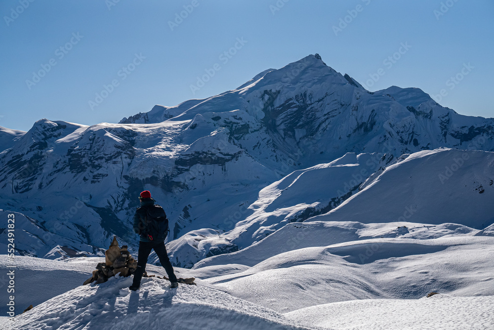 Trekker looking at view of snowy mountrain range on the Annapurna Circuit Trek, Nepal