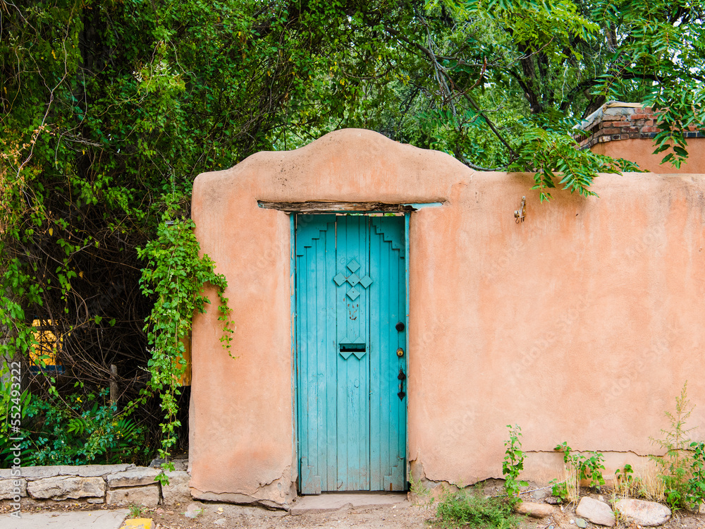 Fototapeta premium Rustic turquoise colored wood door set in an old adobe wall in Santa Fe, New Mexico