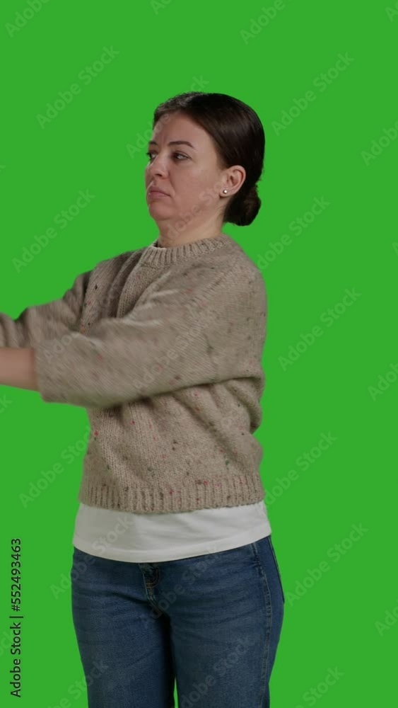 Vertical video: Front view of person showing refusal and pushing thing aside, expressing rejection and denial looking discontent. Female model acting displeased moving object, standing over Vertical video: Front view of person showing refusal and pushing thing aside, expressing rejection and denial looking discontent. Female model acting displeased moving object, standing over