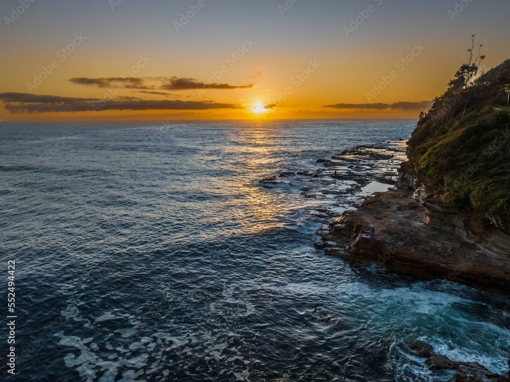Fototapeta premium Sunrise over the ocean with rocks