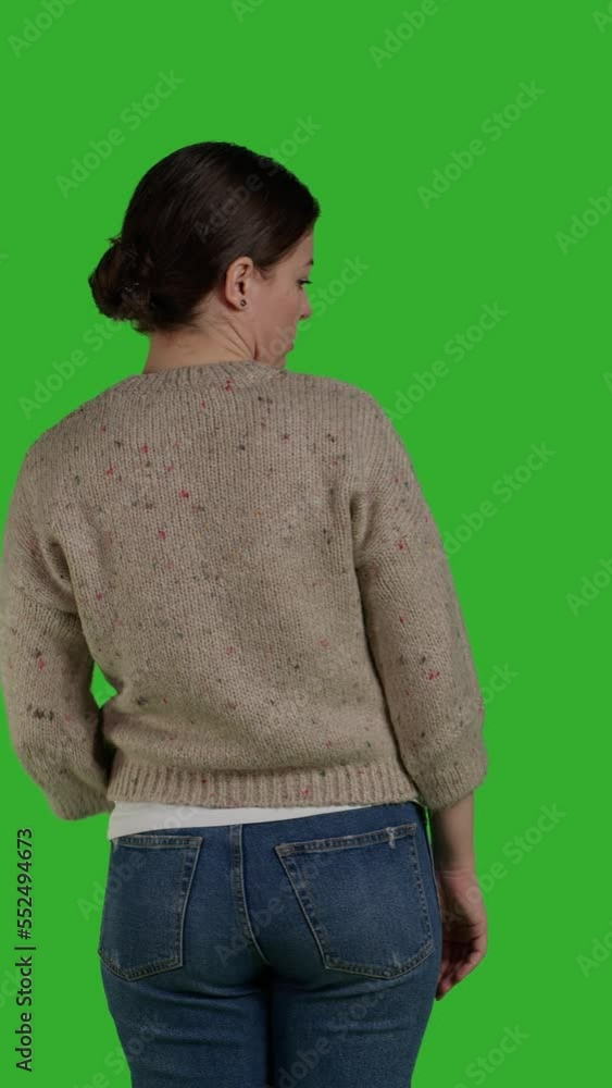 Vertical video: Back view of person showing refusal and pushing thing aside, expressing rejection and denial looking discontent. Female model acting displeased moving object, standing over greenscreen Vertical video: Back view of person showing refusal and pushing thing aside, expressing rejection and denial looking discontent. Female model acting displeased moving object, standing over greenscreen