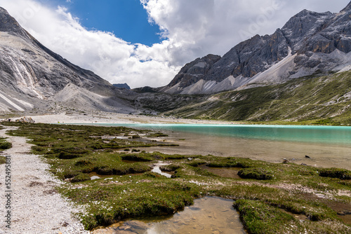 Fototapeta Naklejka Na Ścianę i Meble -  Unique colored Milk lake (about 4600m altitude) with blue sky and sharp mountains around it in Daocheng Yading Nature Reserve, Sichuan, China.