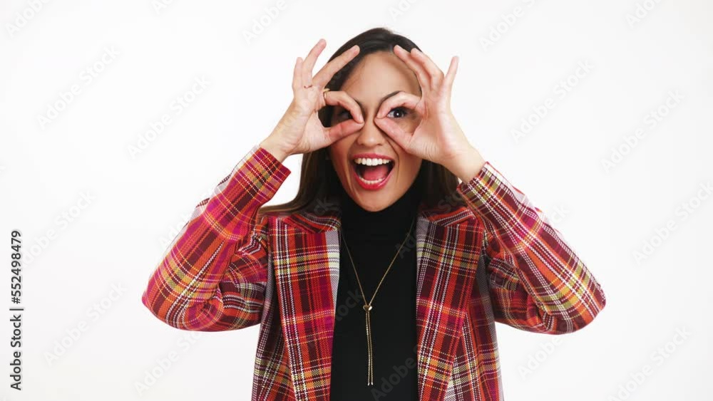 Portrait of a happy young woman making circles using her hands around her eyes and smiling at the camera, isolated. High quality 4k footage Portrait of a happy young woman making circles using her hands around her eyes and smiling at the camera, isolated. High quality 4k footage