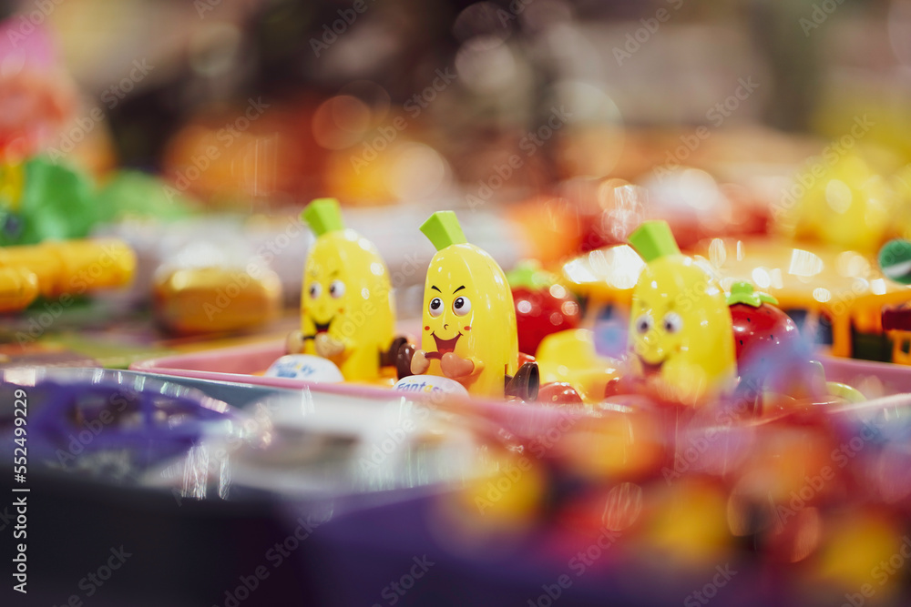 A banana fruit Toy with happy cartoon face,A yellow color scooter toy, children toys in yellow color selling in market, fair, mall, or store