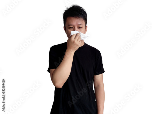 Young man in black shirt holding nose with tissue with straight face expression isolated on white background