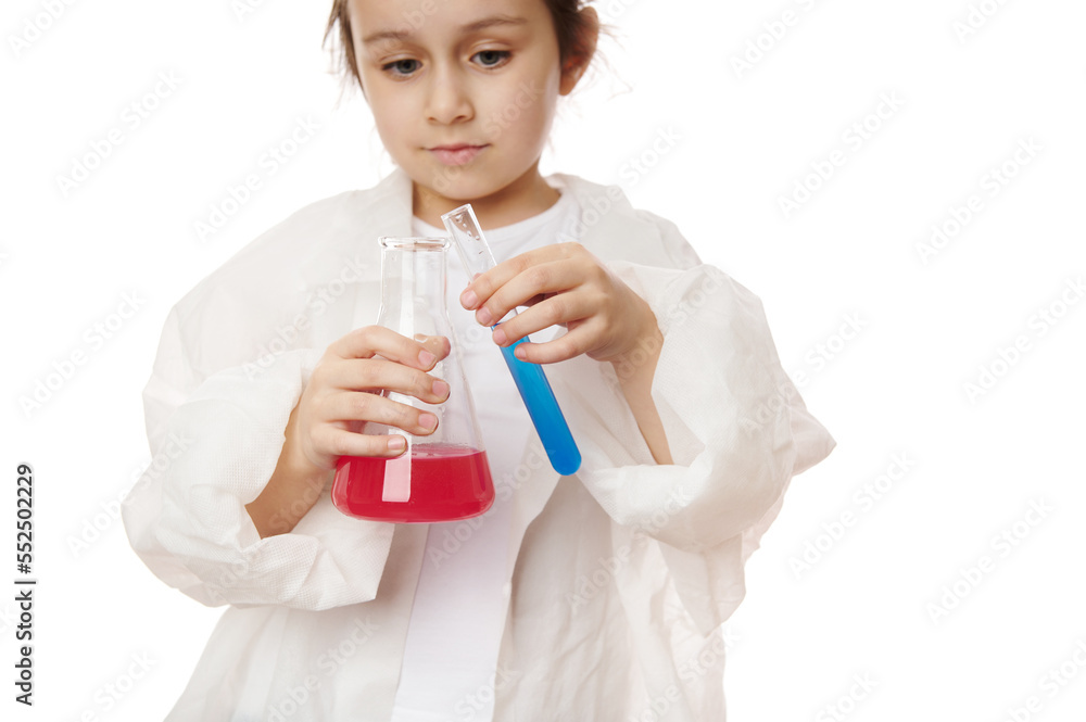 Details: little chemist's hands hold test tube with blue fluid reagent and a flat bottomed flask with chemical solution. Close-up smart kid conducting experiments at chemistry class, white background Details: little chemist's hands hold test tube with blue fluid reagent and a flat bottomed flask with chemical solution. Close-up smart kid conducting experiments at chemistry class, white background