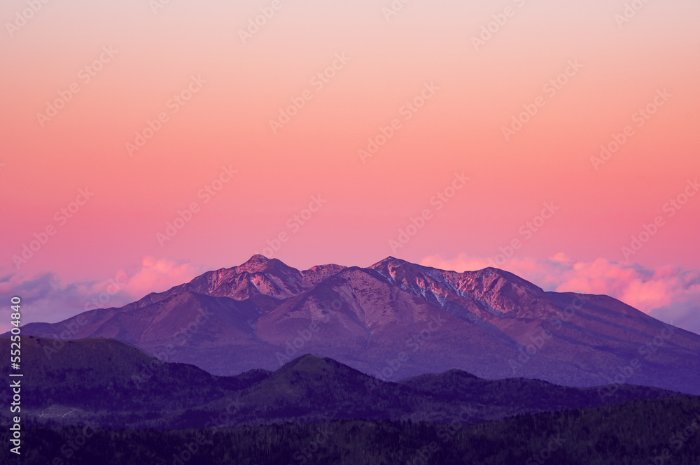 ピンク色に染まる空と山の稜線。日本の北海道の斜里岳。