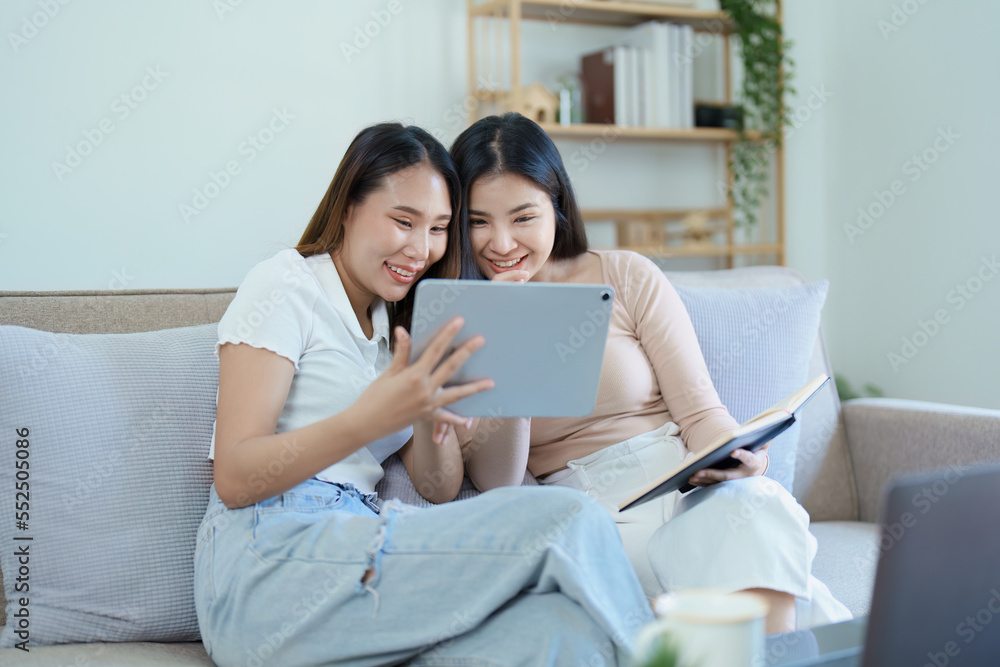 lgbtq, lgbt concept, homosexuality, portrait of two asian women posing happy together and loving each other while playing tablet at sofa lgbtq, lgbt concept, homosexuality, portrait of two asian women posing happy together and loving each other while playing tablet at sofa