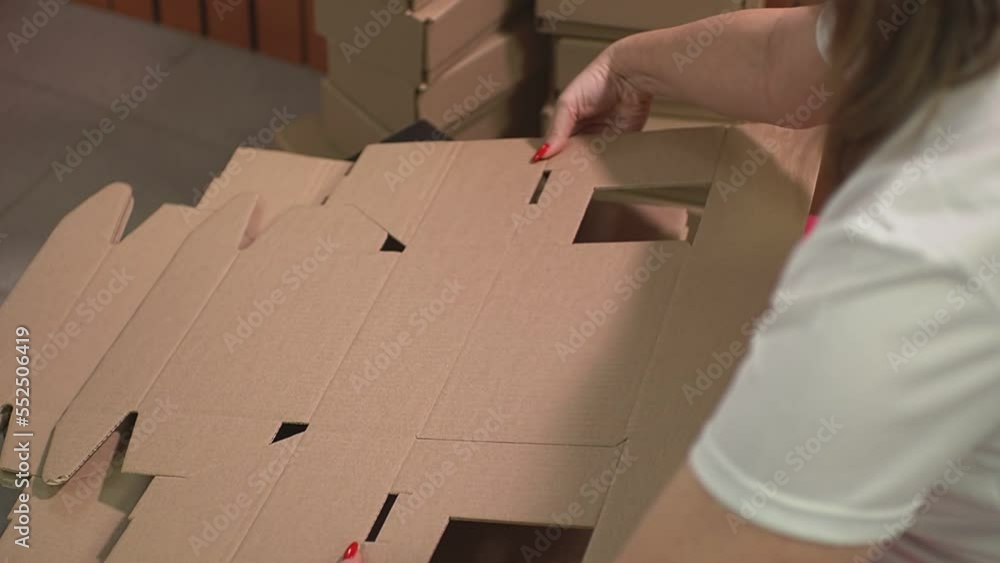 a girl with a red manicure collects a cardboard box. High-quality Full HD video recording. slow motion video a girl with a red manicure collects a cardboard box. High-quality Full HD video recording. slow motion video
