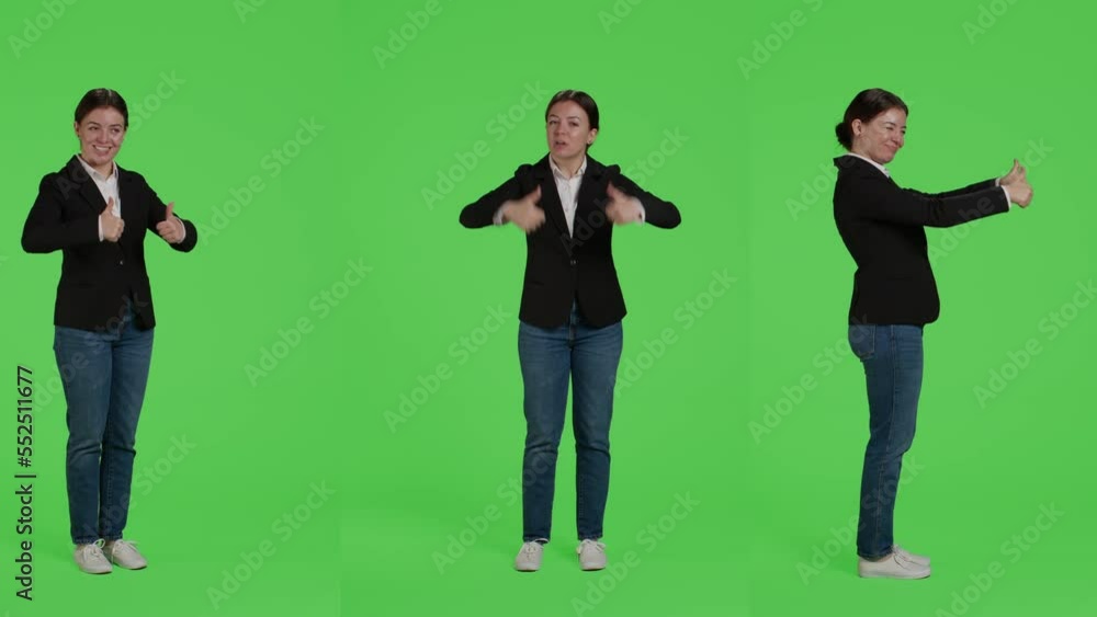 Businesswoman giving thumbs up over green screen studio backdrop, expressing like and approval on camera. Office worker in suit doing okay agreement gesture, acting positive and cheerful. Businesswoman giving thumbs up over green screen studio backdrop, expressing like and approval on camera. Office worker in suit doing okay agreement gesture, acting positive and cheerful.