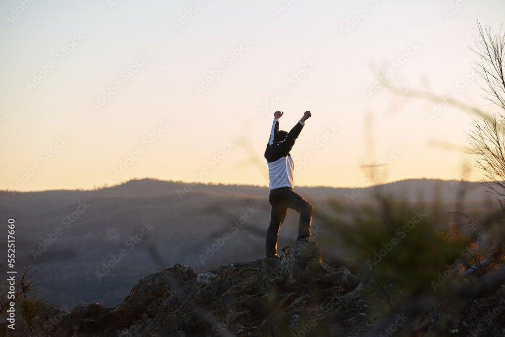 Man standing looking out over mountains on sunset Man standing looking out over mountains on sunset