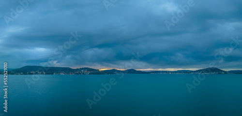 Sunrise waterscape panorama with rain clouds moving in