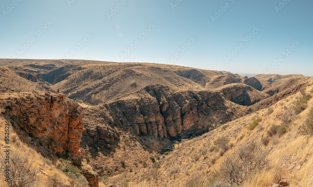 Atemberaubender Panoramablick auf dem Olive Trail - Familie blickt von einem Aussichtspunkt aus in eine enge felsige Schlucht mit Felswänden aus Sedimentgestein, Naukluft Gebirge, Namibia