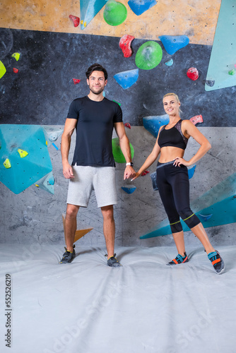 Bouldering Concepts. One Joyful couple Preparing To Bouldering climbing up the wall together.