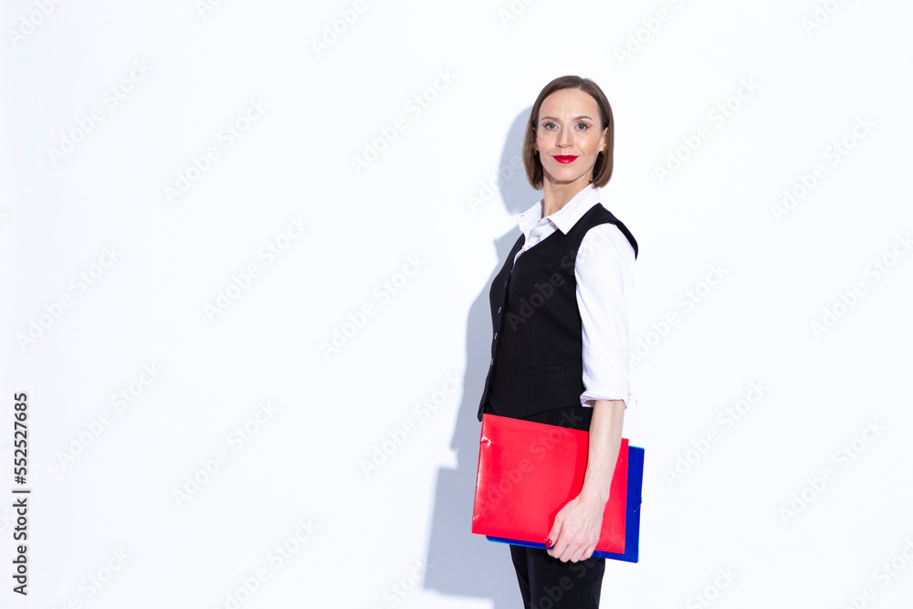 Women In Business. Portrait of Winsome Positive Confident Caucasian Business Woman in White Shirt and Suit Posing With Folders Over White Background. Women In Business. Portrait of Winsome Positive Confident Caucasian Business Woman in White Shirt and Suit Posing With Folders Over White Background.