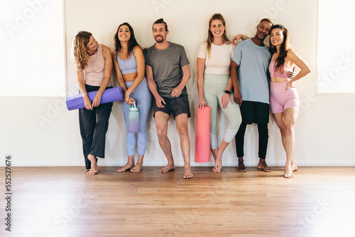Group of diverse people smiling while standing in a yoga studio