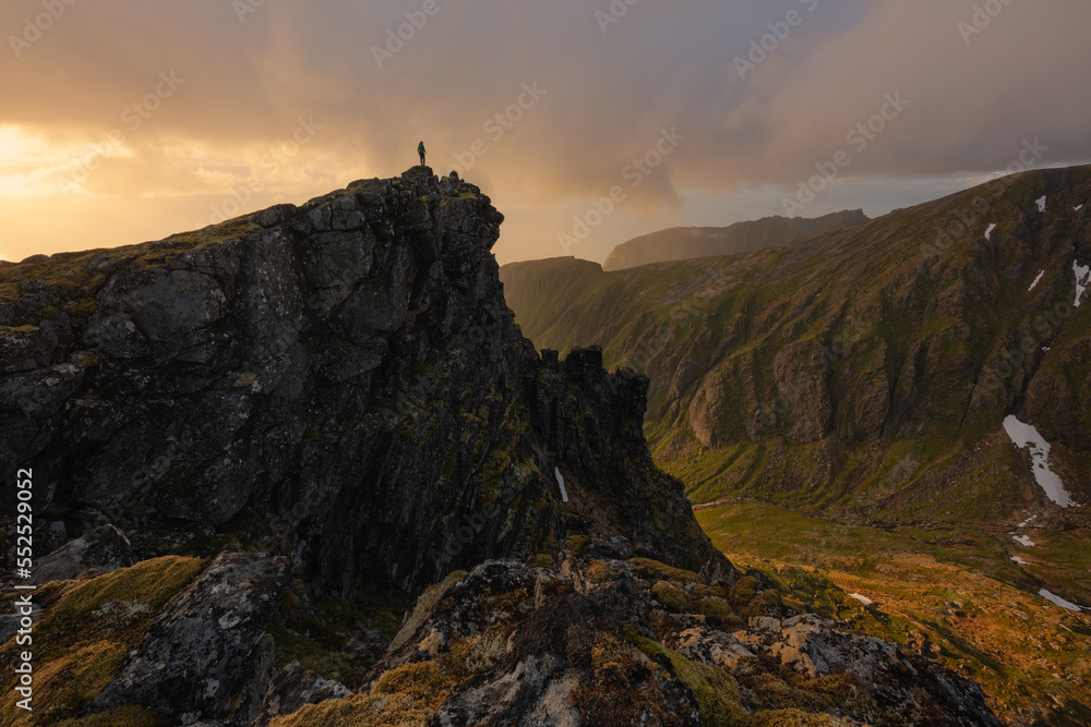 Hiker standing on the summit of Kleivheia, Lofoten Islands, Norway Hiker standing on the summit of Kleivheia, Lofoten Islands, Norway