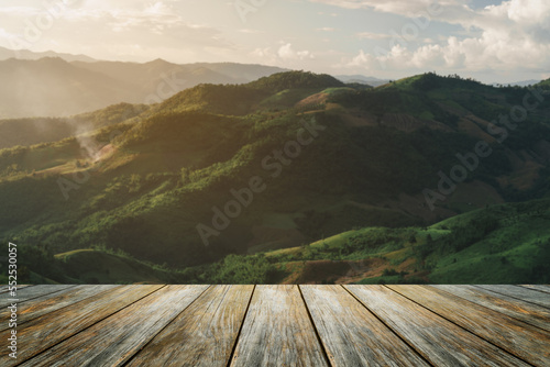 Fotografía Wooden table terrace and Sunrise landscape with mountain and sun lighting under vibrant colorful morning sky in mountains