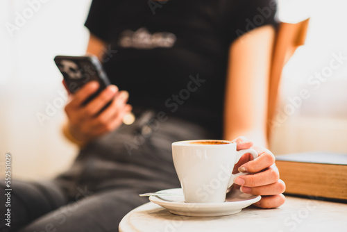 Young Asian woman's hand using smartphone while sitting in a cafe