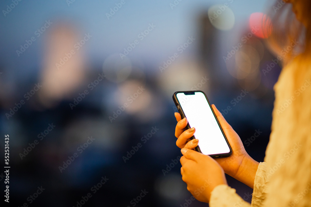 Close up of female hands using mobile smartphone in bright yellow bokeh lights in night city. Close up of female hands using mobile smartphone in bright yellow bokeh lights in night city.