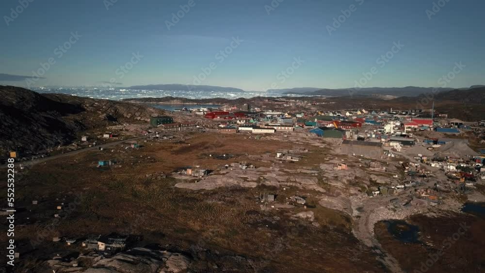 Aerial view of Ilulissat from the ice fiord center, pulling back, and tilting down, over the dogs Aerial view of Ilulissat from the ice fiord center, pulling back, and tilting down, over the dogs