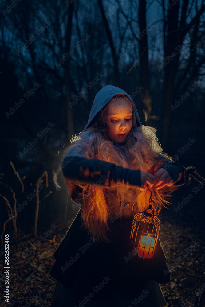Girl with candle in the night forest