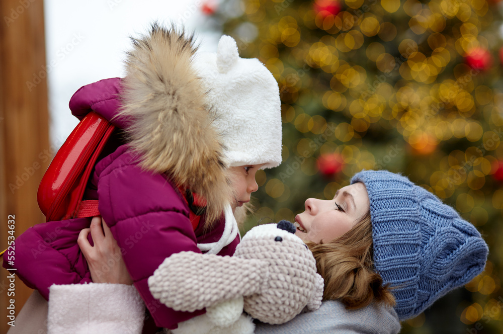 Mother and daughter are walking around the city on Christmas and New Year holidays. Portrait of happy mother and daughter having fun in the street Mother and daughter are walking around the city on Christmas and New Year holidays. Portrait of happy mother and daughter having fun in the street
