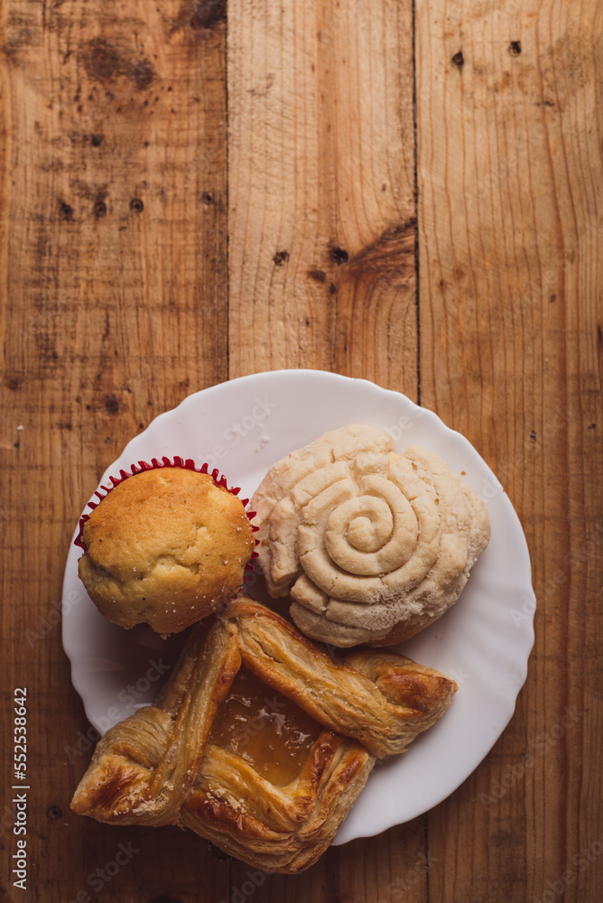 Concha and other sweet breads on wooden table. Typical Mexican desserts. Concha and other sweet breads on wooden table. Typical Mexican desserts.