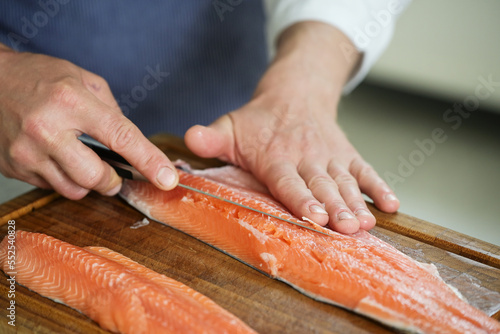 Εκτύπωση καμβά char fish filleting, hands of the cook remove the bones with a thin fillet knife