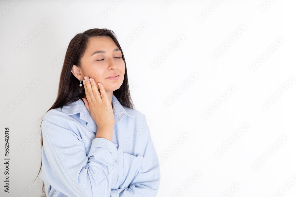 Portrait of a beautiful brunette woman in a blue shirt on a white background. Neutral makeup. Space for text Portrait of a beautiful brunette woman in a blue shirt on a white background. Neutral makeup. Space for text