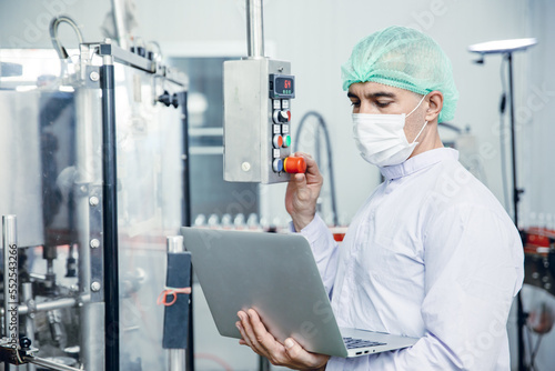 food and drink industry staff worker working at conveyor belt production line machine in beverage factory with clean and hygiene area.