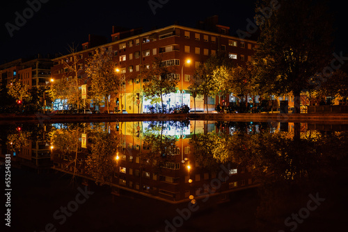 Residential district with apartment buildings reflected in the water at night